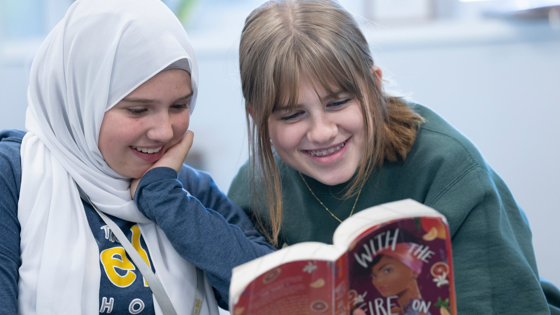 photo fo two students reading a book together