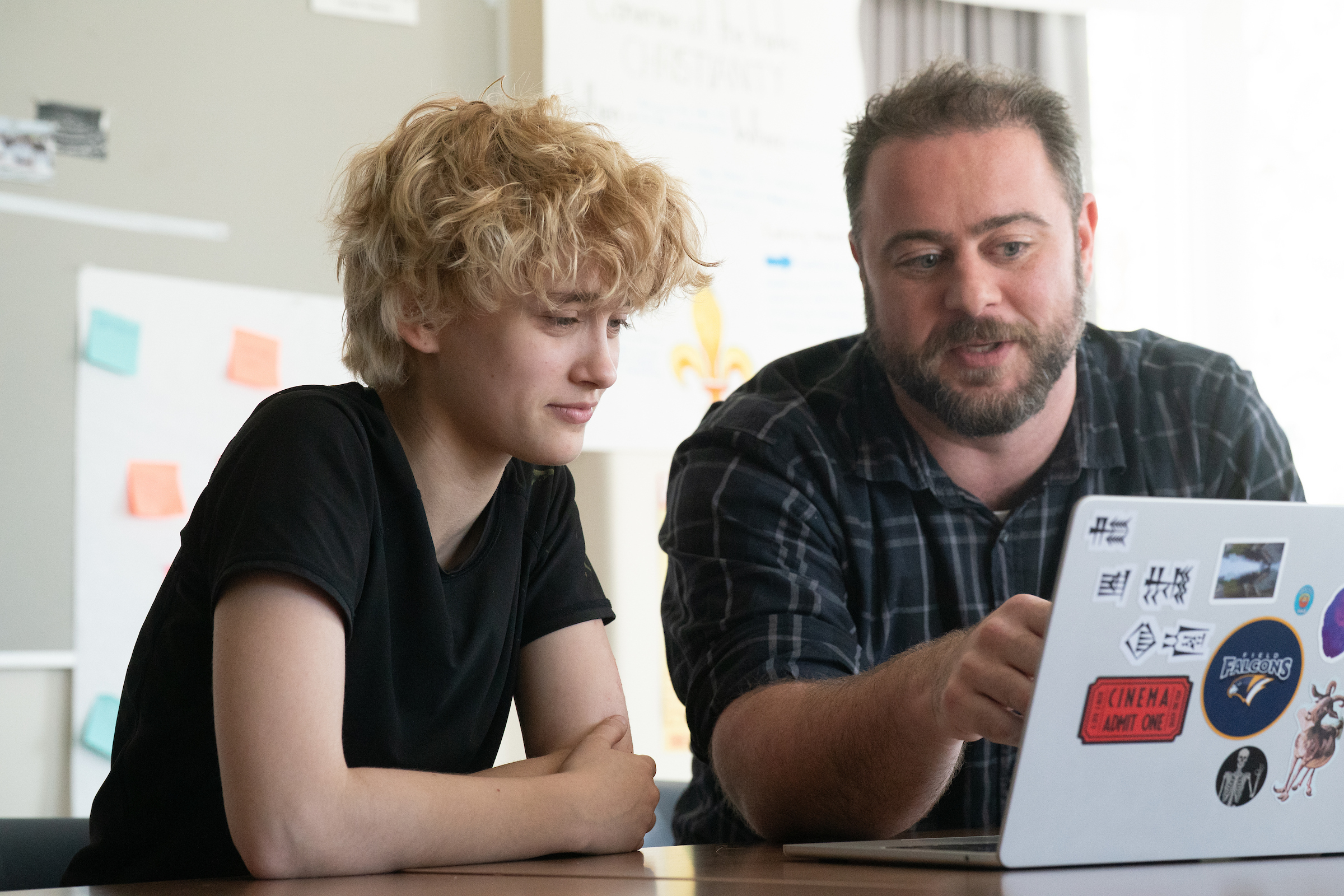 photo of teacher and one student looking at laptop