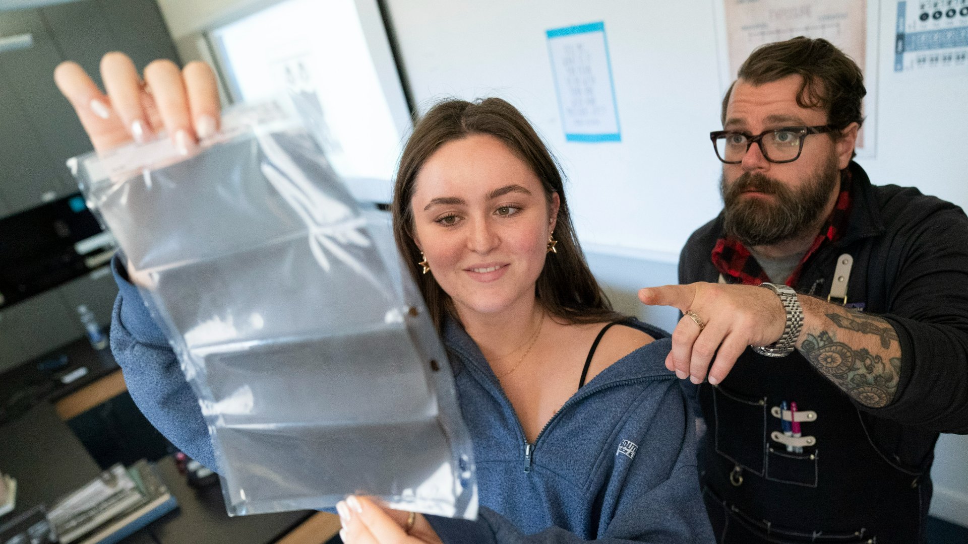photo of student and teahcer looking at film negatives