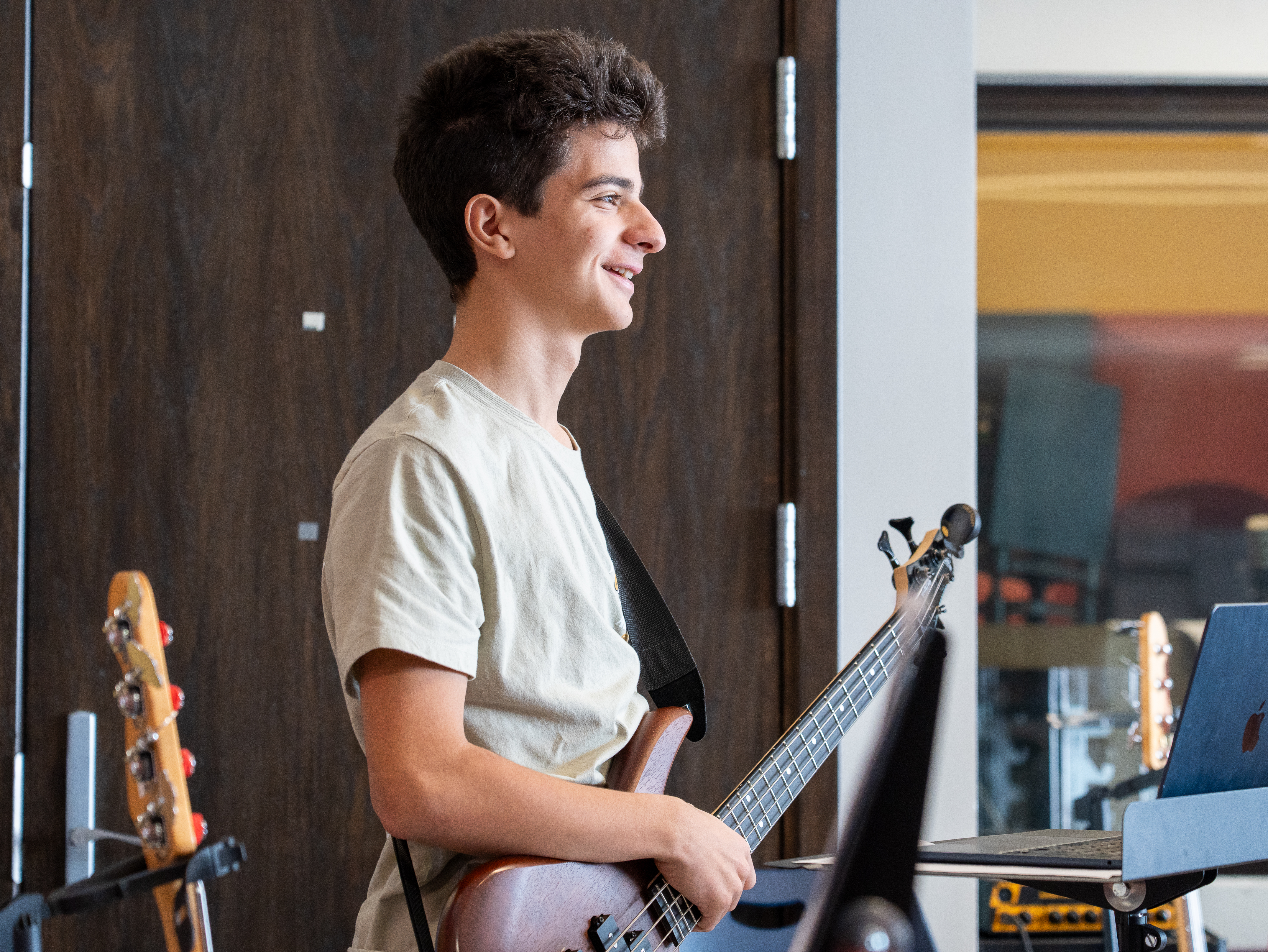 Student playing guitar and smiling